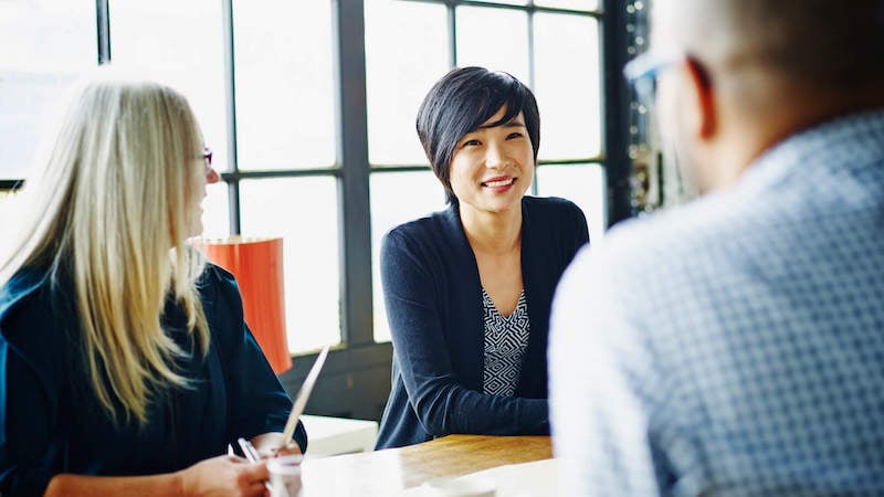 contingency-theory-of-leadership-leader-at-team-meeting-smiling