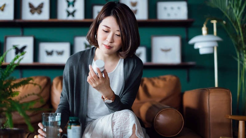 invisible-illness-woman-with-pills-on-couch