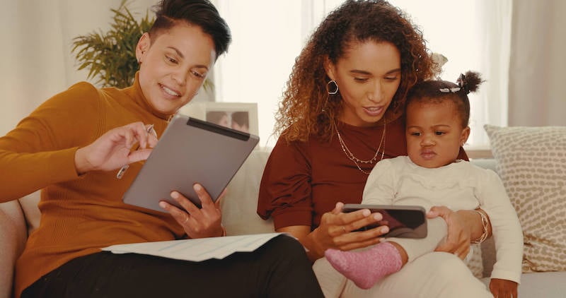 LGBTQ-acceptance-lesbian-couple-with-child-on-couch