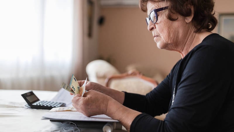 mental-health-and-money-woman-counting-money-at-table