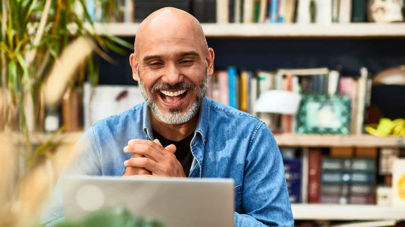 virtual-team-building-man-laughing-on-laptop