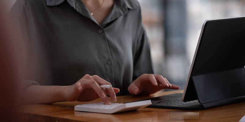 wage-compression-fingers-typing-on-calculator
