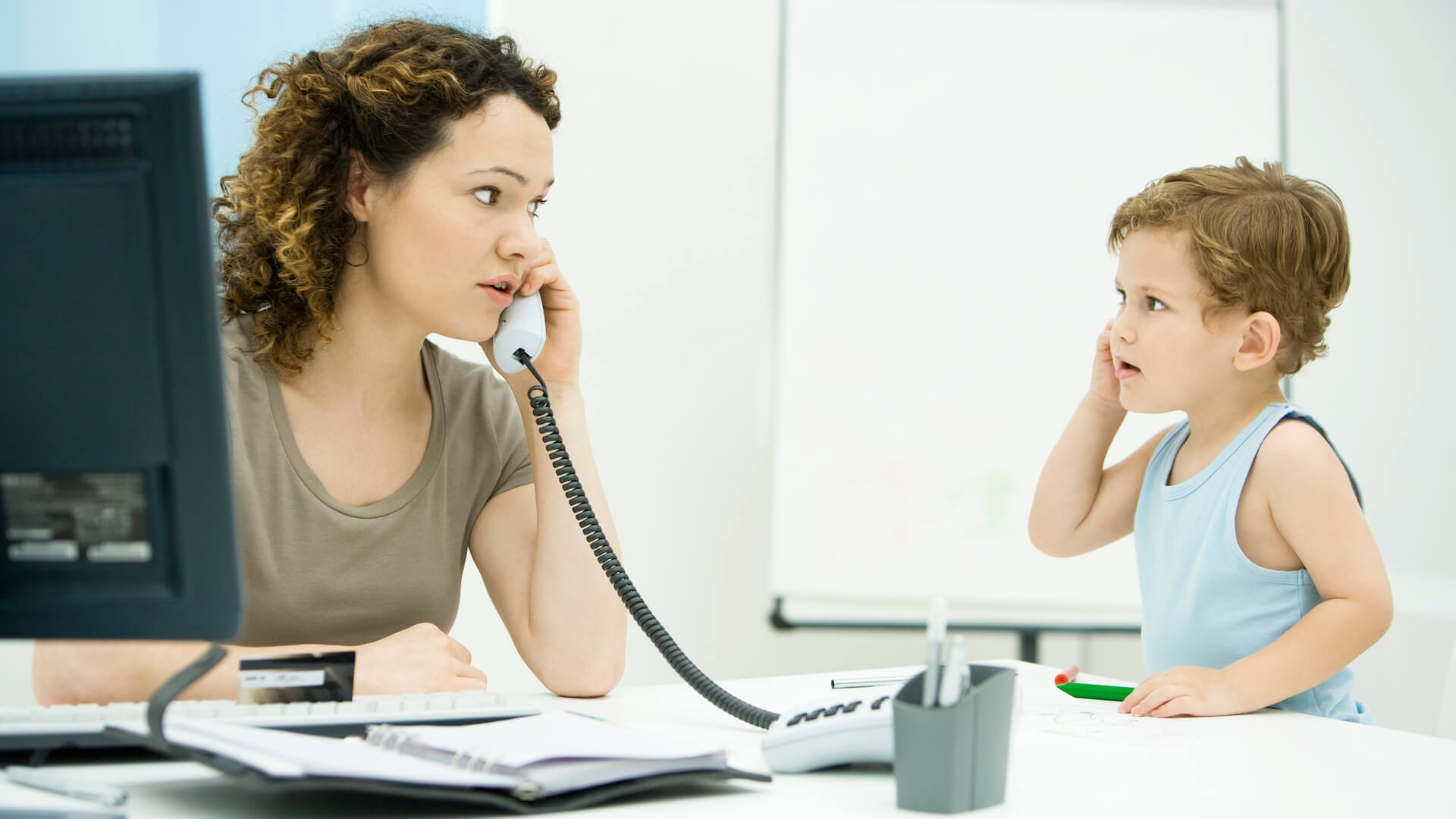 balance-family-and-work-parent-looks-at-kid-while-on-phone