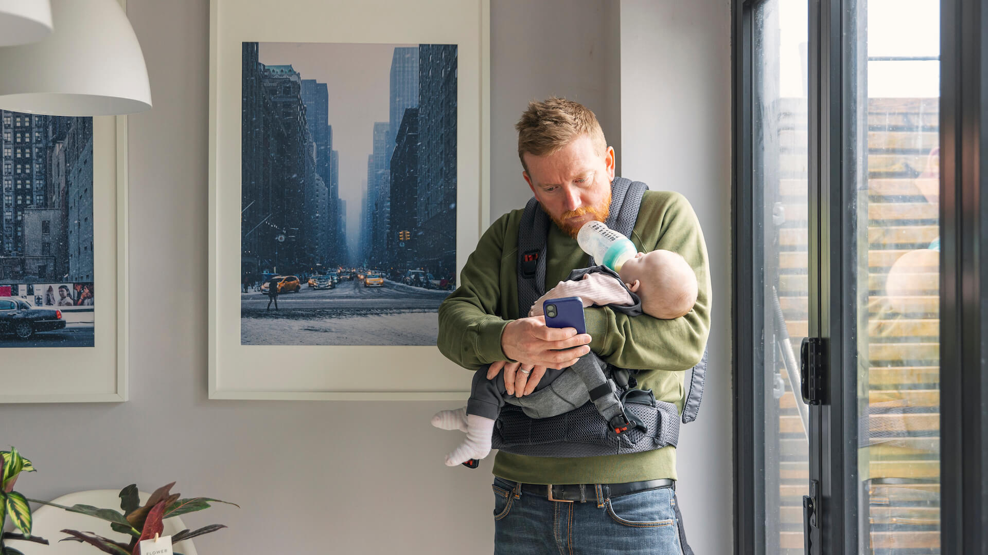 balance-family-and-work-parent-using-chin-for-baby-bottle-on-phone