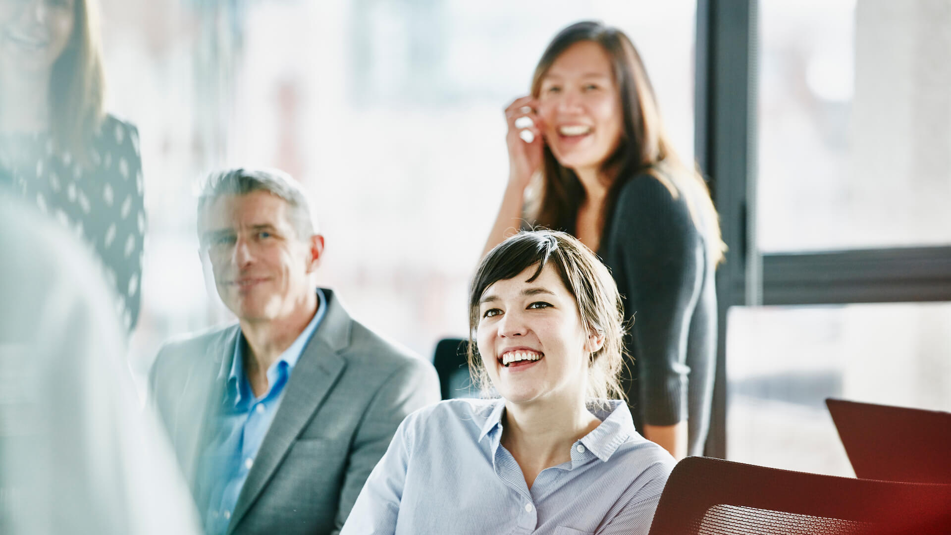 coaching-leadership-style-examples-team-smiling-in-an-office