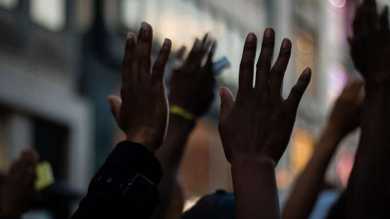 collective-trauma-hands-up-at-a-protest