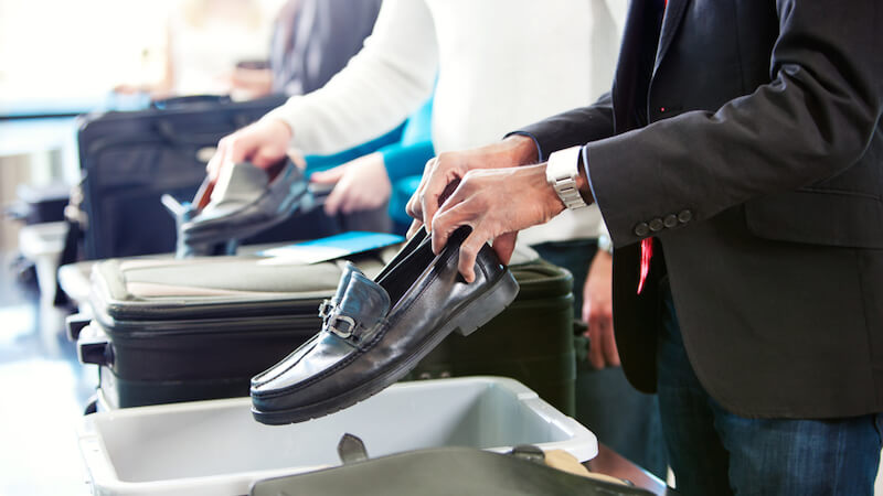 collective-trauma-putting-shoes-in-airport-security-bin