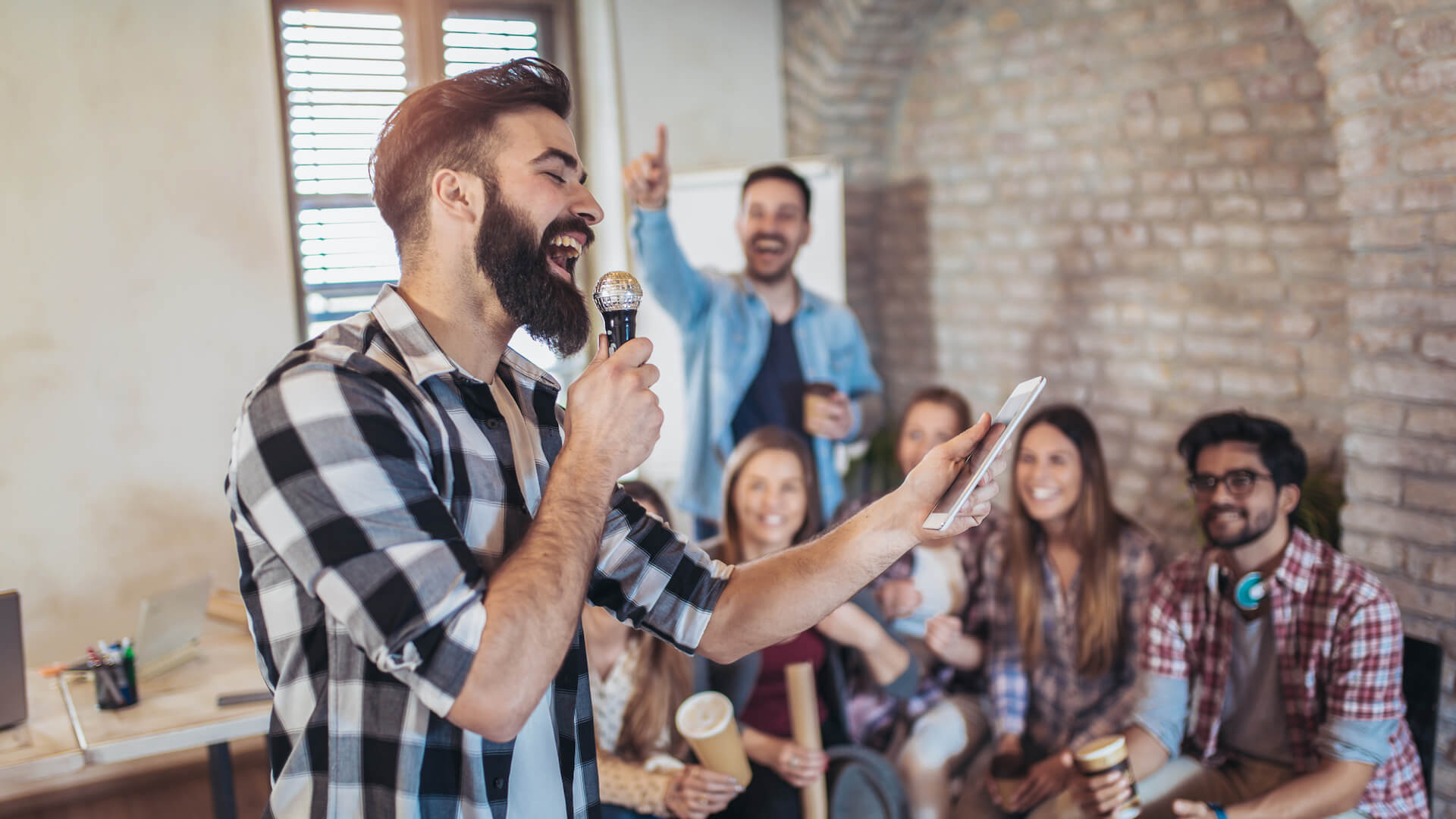 company-retreat-team-does-karaoke-in-office