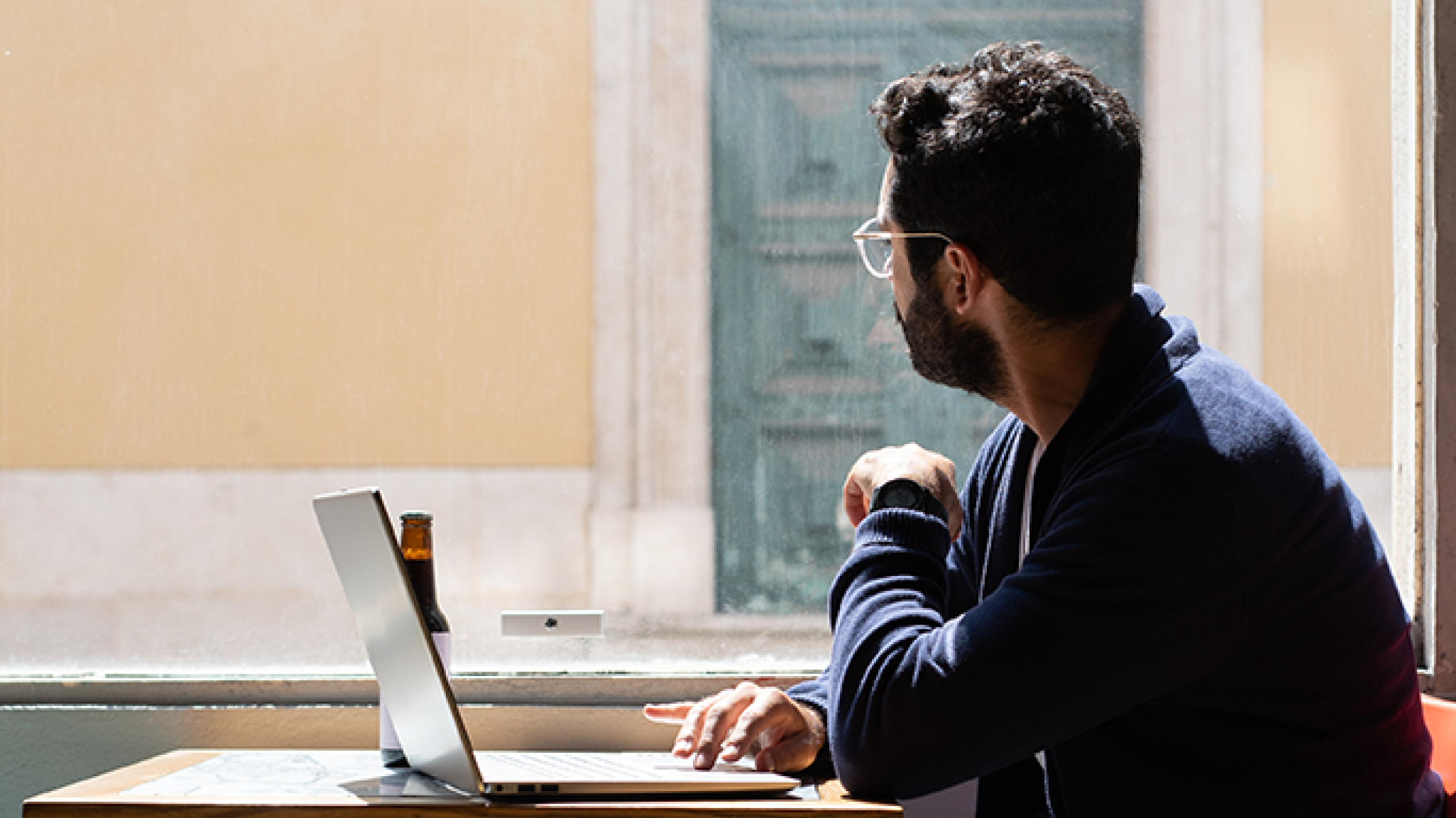 man-at-laptop-stares-out-window-the-connection-crisis-why-community-matters