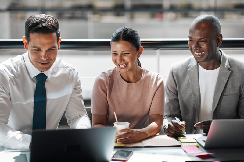 three-employees-sitting-happily-side-by-side-distributed-leadership