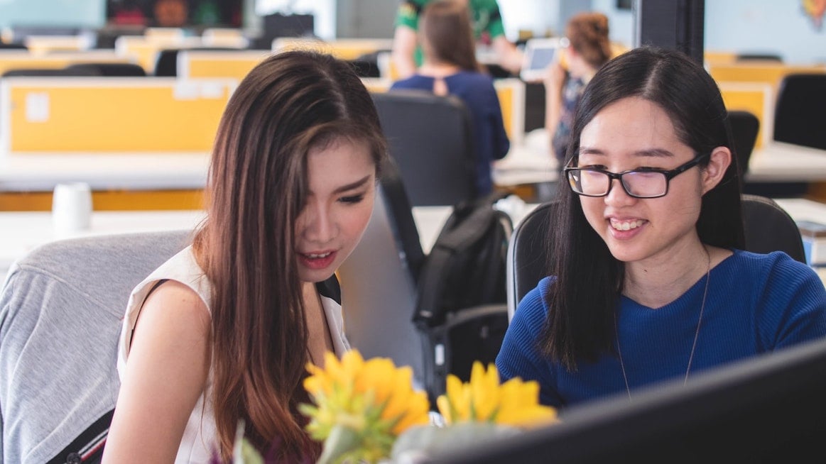 employer-brand-2-women-work-at-computer-yellow-flowers
