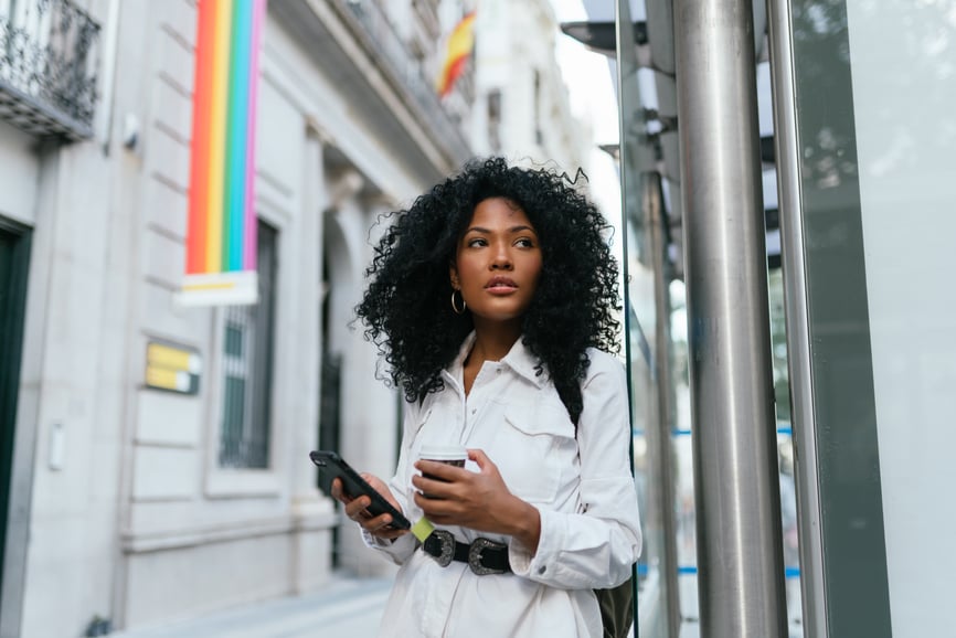 woman-holding-phone-and-drink-lgbtq-flag-expert-power