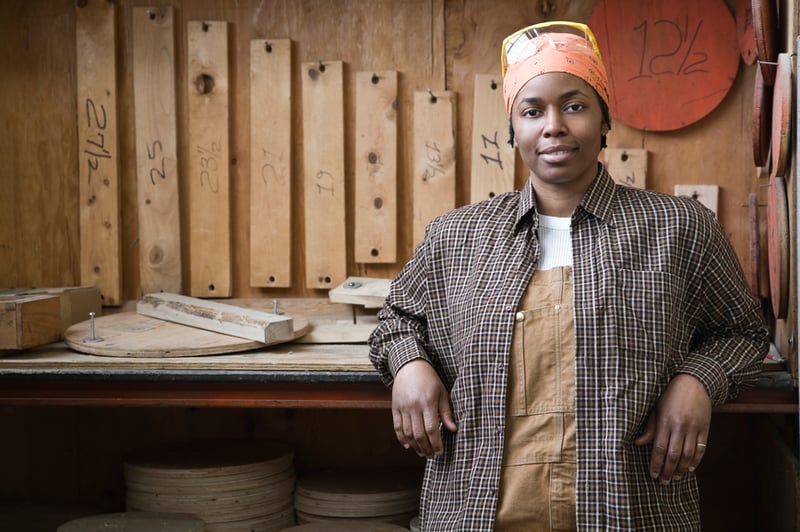 factory-worker-smiling-near-work-bench-capital resources