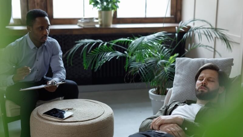grief-therapy-male-therapist-talks-to-person-on-couch