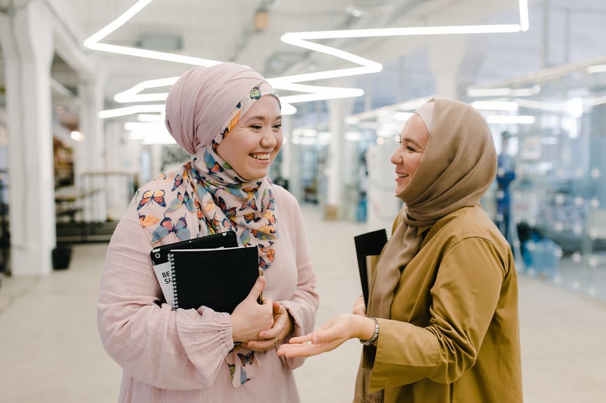 happy-colleagues-chatting-in-hallway-how-to-carry-a-conversation