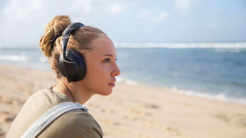 mental-health-podcast-person-listens-to-podcast-on-beach