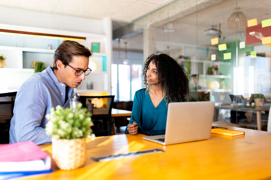 male-and-female-colleague-talking-with-laptop-reverse-mentoring