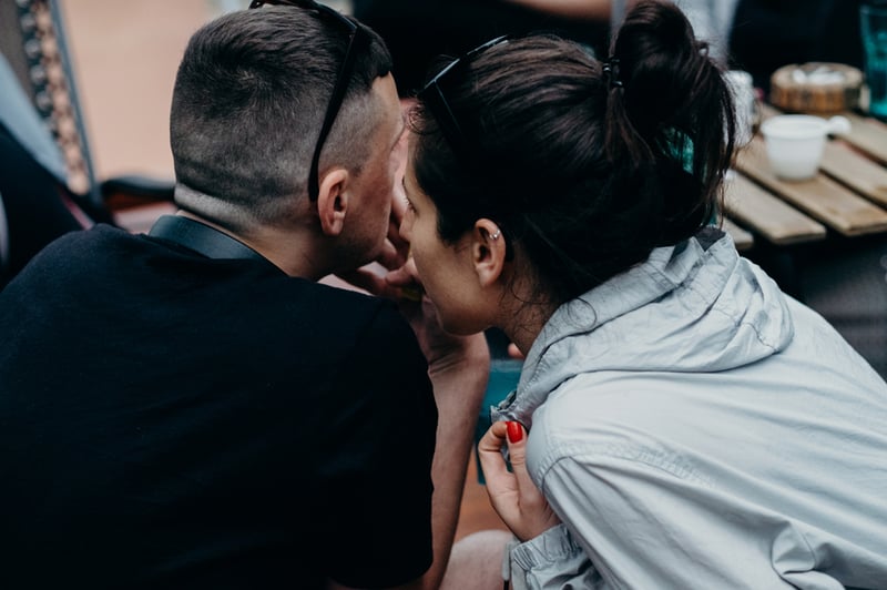 woman-whispering-into-a-mans-ear-gaslighting-at-work