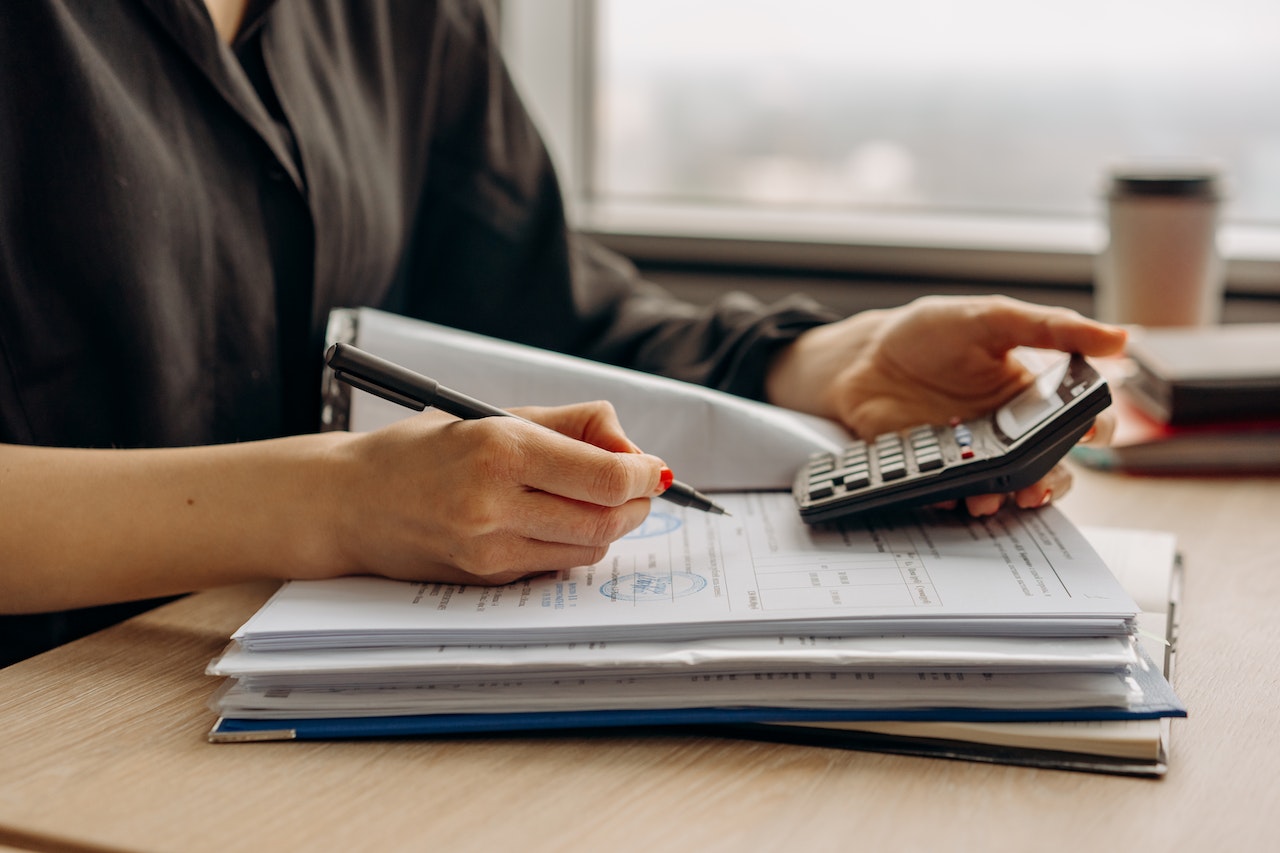 Close-up-of-womans-hands-using-calculator-and-holding-pen-voluntary-layoffs