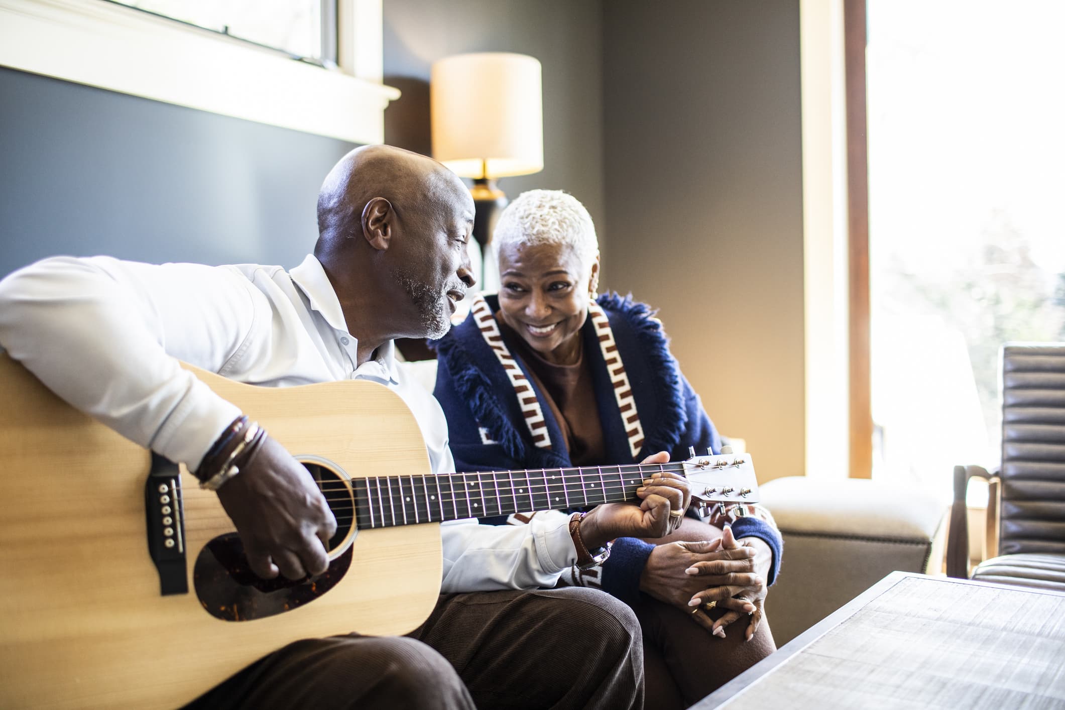 Elderly-man-playing-an-acoustic-guitar-to-his-smiling-wife-toxic-productivity