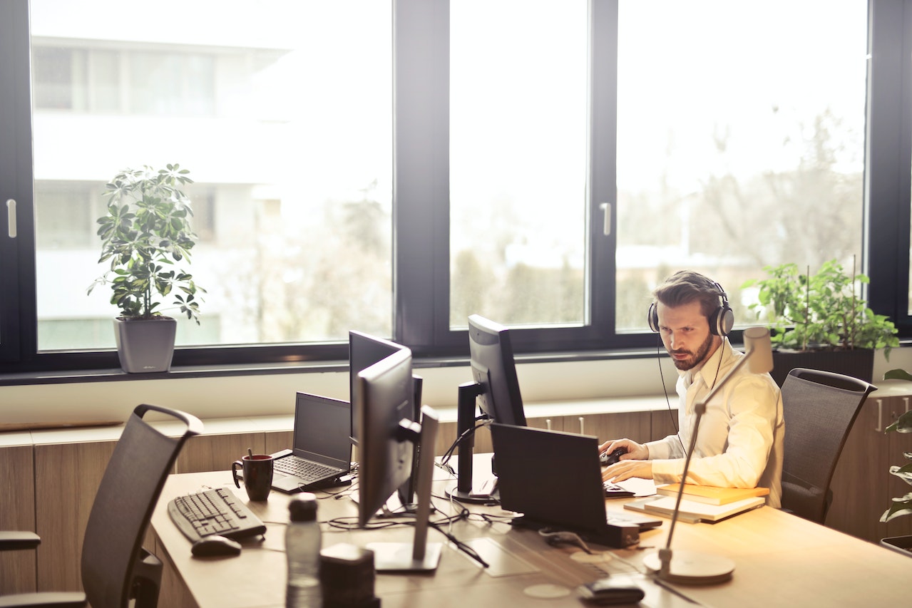 Man-with-headphones-at-office-working-on-computer-start-stop-continue