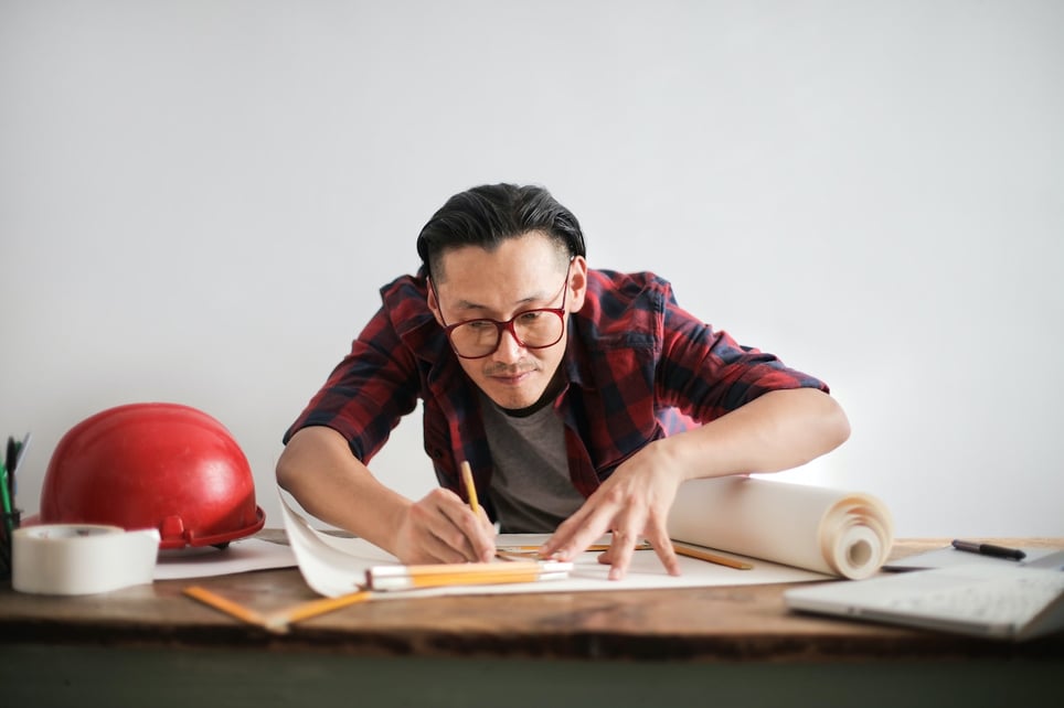 Man-working-on-paper-with-ruler-at-studio-personal-branding