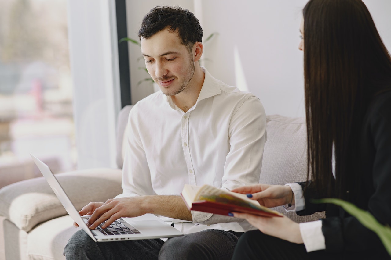 Man-writing-email-on-laptop-with-his-friend-entry-level-salary-negotiation-example