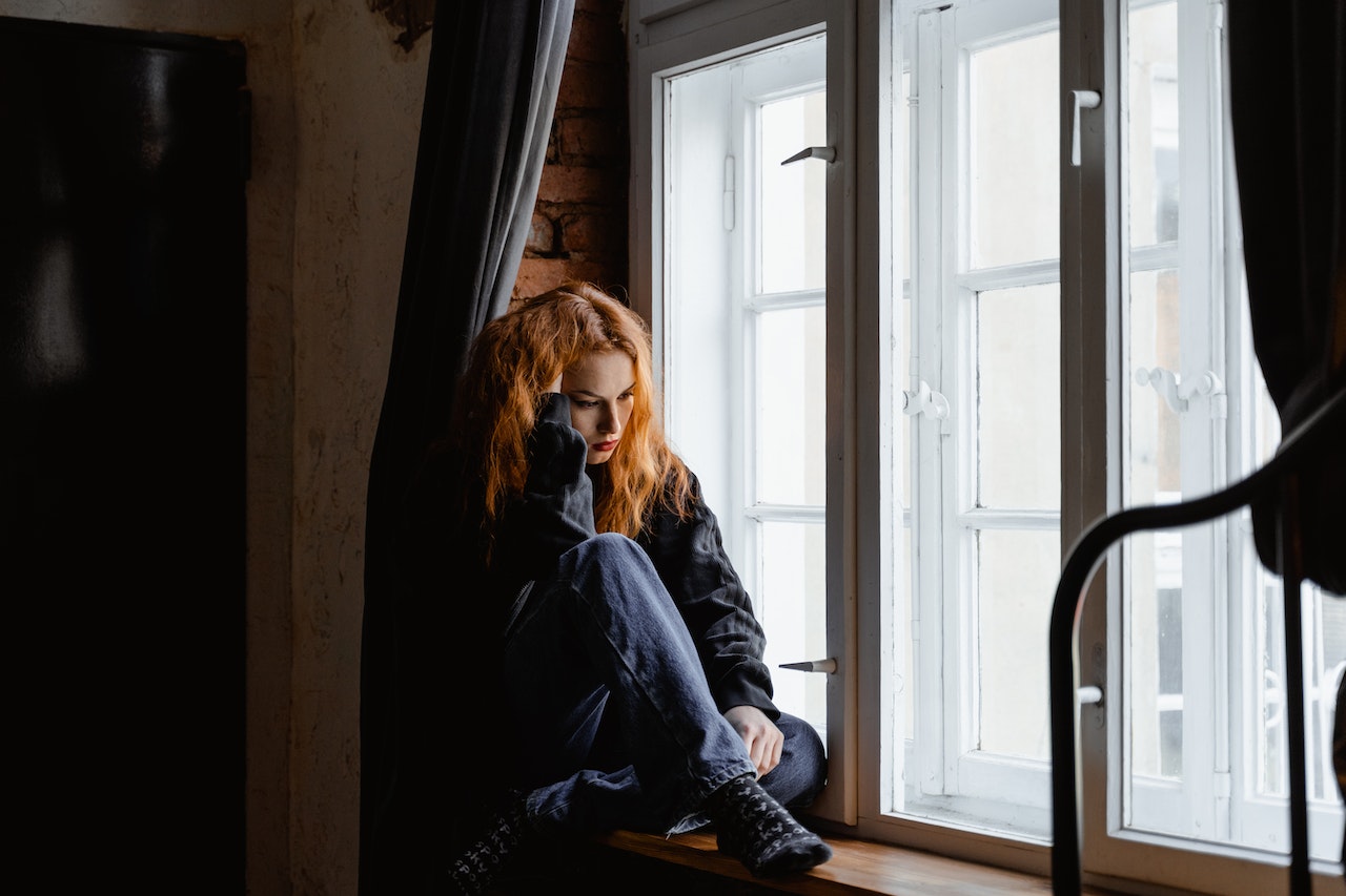 Sad-woman-sitting-besides-bedroom-window-why-cant-i-keep-a-job