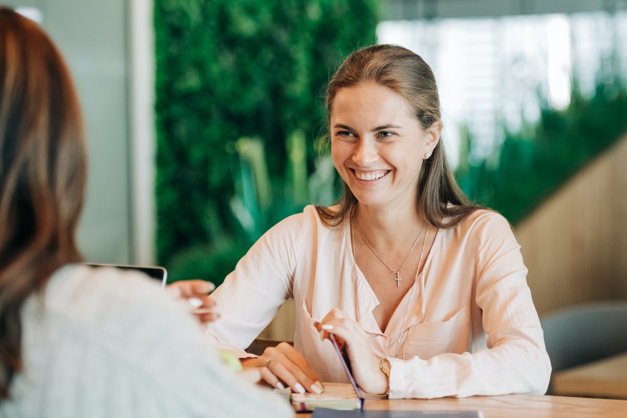 Smiling-woman-talking-to-someone-else-at-office-voluntary-layoffs