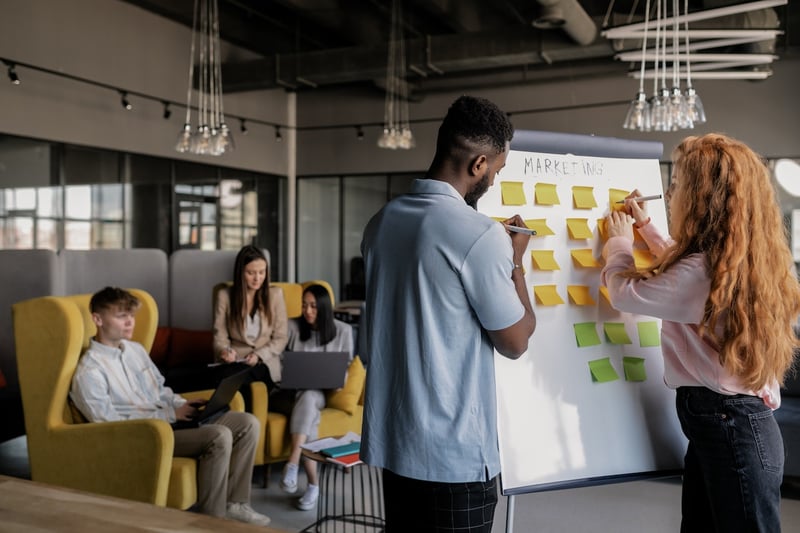 Team-working-together-using-whiteboard-and-post-its-start-stop-continue