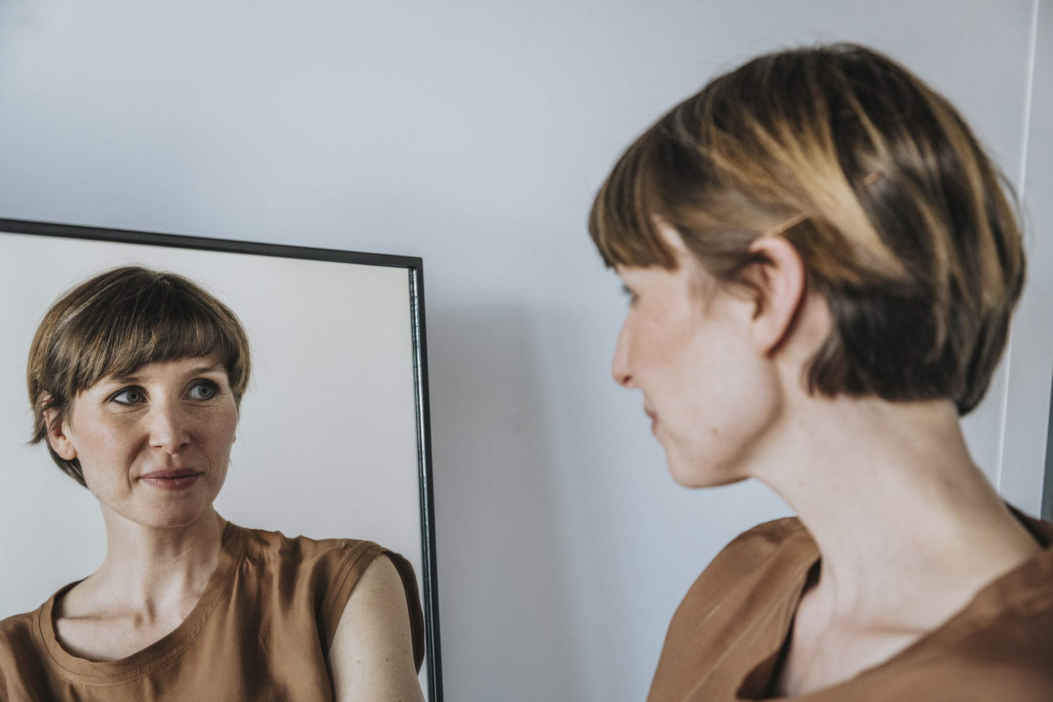 Thoughtful woman looking-at-reflection-in-mirror-the-importance-of-knowing-yourself