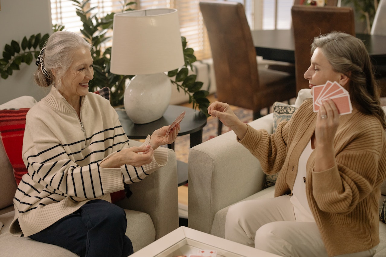 Two-elderly-ladies-playing-with-cards-at-home-quality-time-with-family