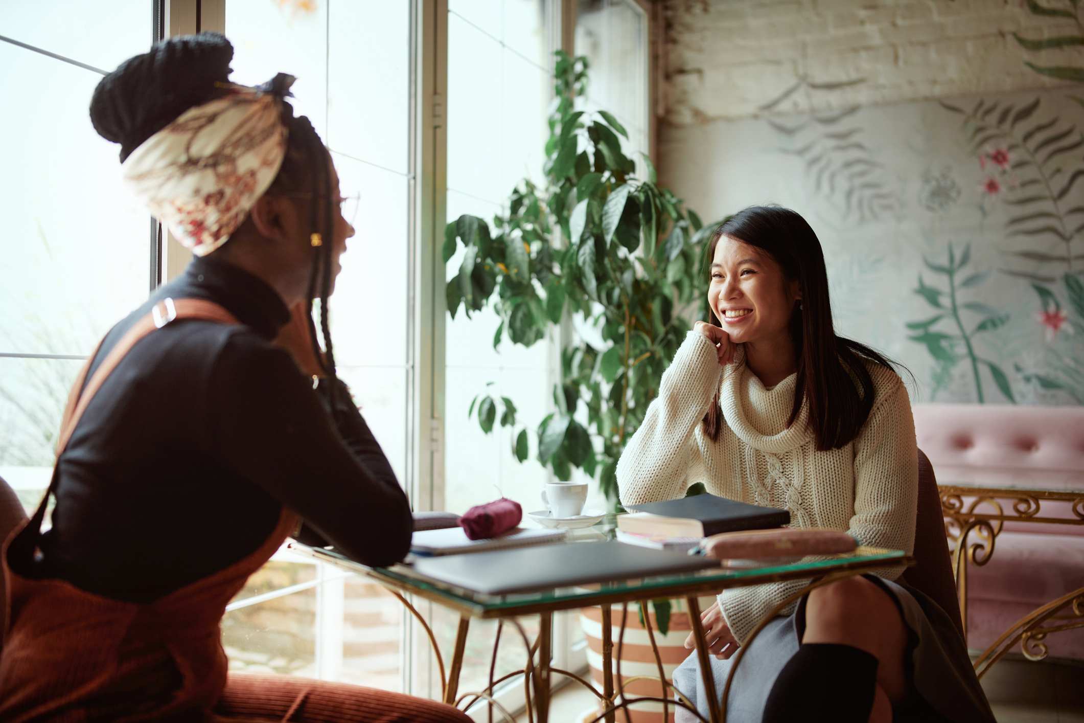 Two-happy-multicultural-female-college-girls-sit-in-the-cafeteria-how-to-write-a-letter-of-recommendation