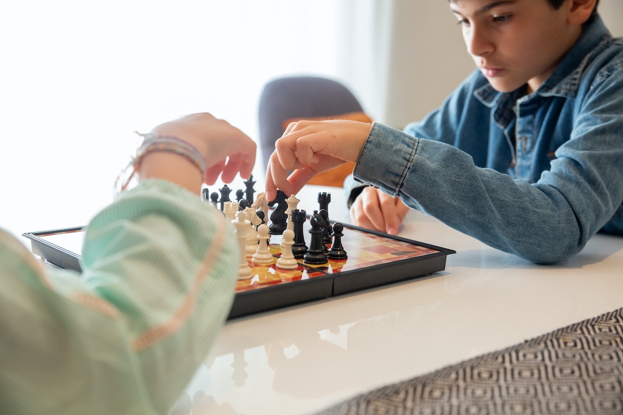 Two-kids-playing-chess-at-home-how-to-use-100-of-your-brain