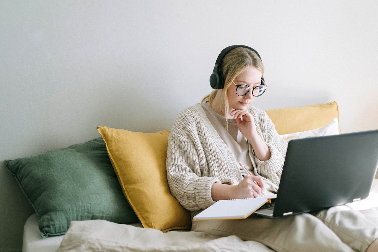 Woman-with-headphones-at-home-writing-on-notebook-and-laptop-resume-dos-and-donts