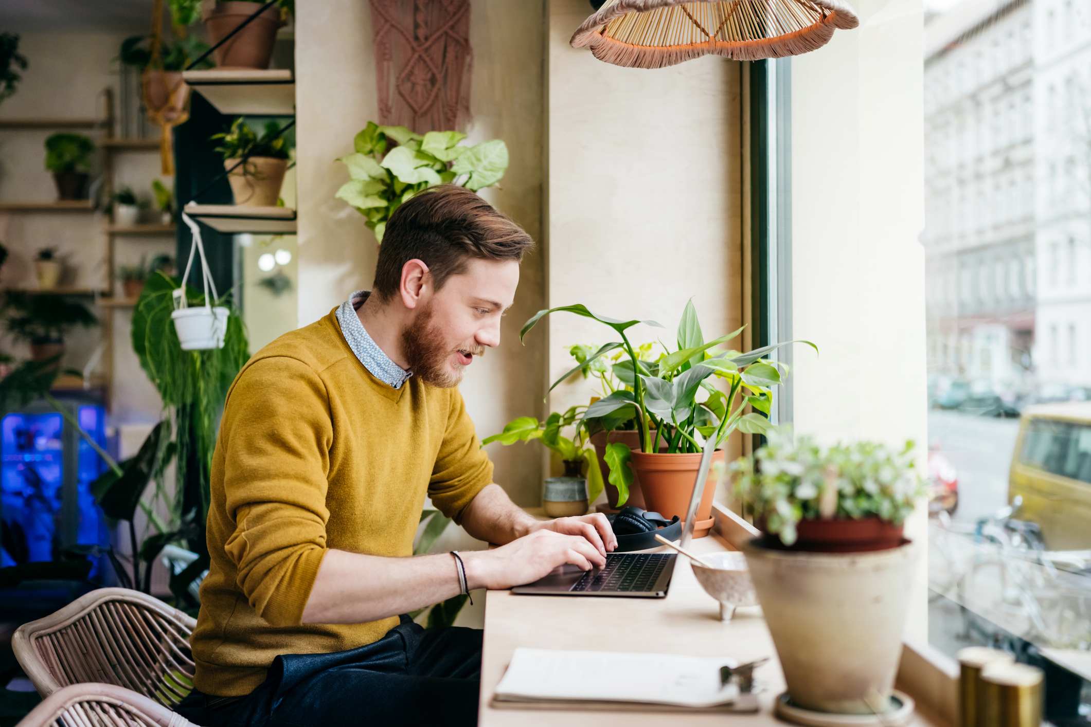 Young-Man-Sitting-In-Cafe-Using-Laptop-why-should-we-hire-you-answer