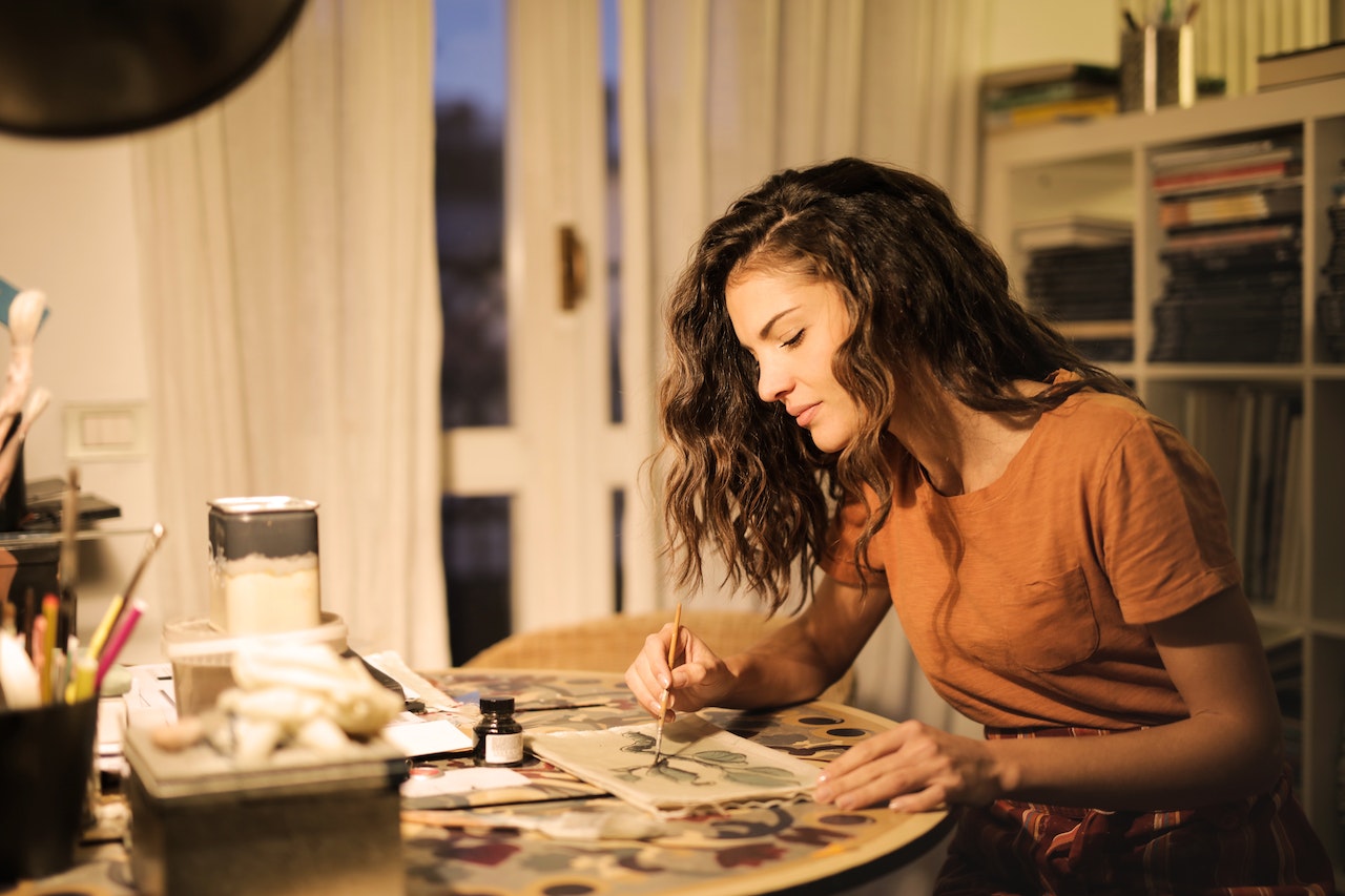 Young-woman-painting-on-paper-at-workplacehow-to-get-inspired