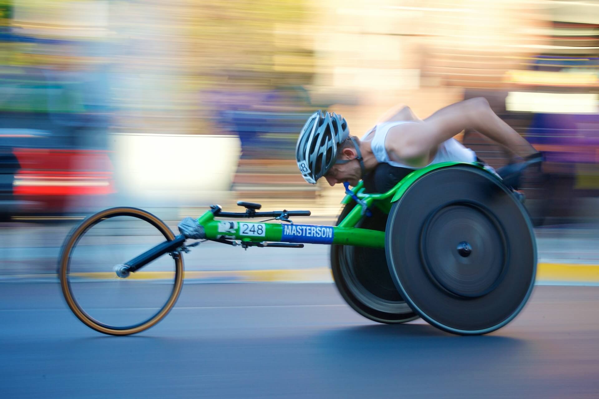 athlete in a greenwheelchair racing