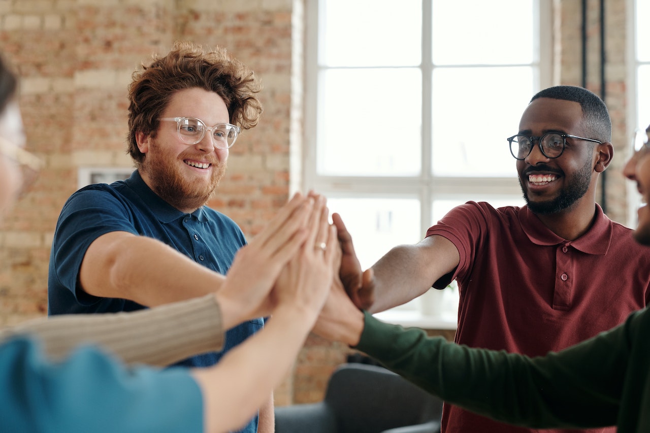 colleagues-giving-high-five-to-each-other-at-office-work-anniversary-messages