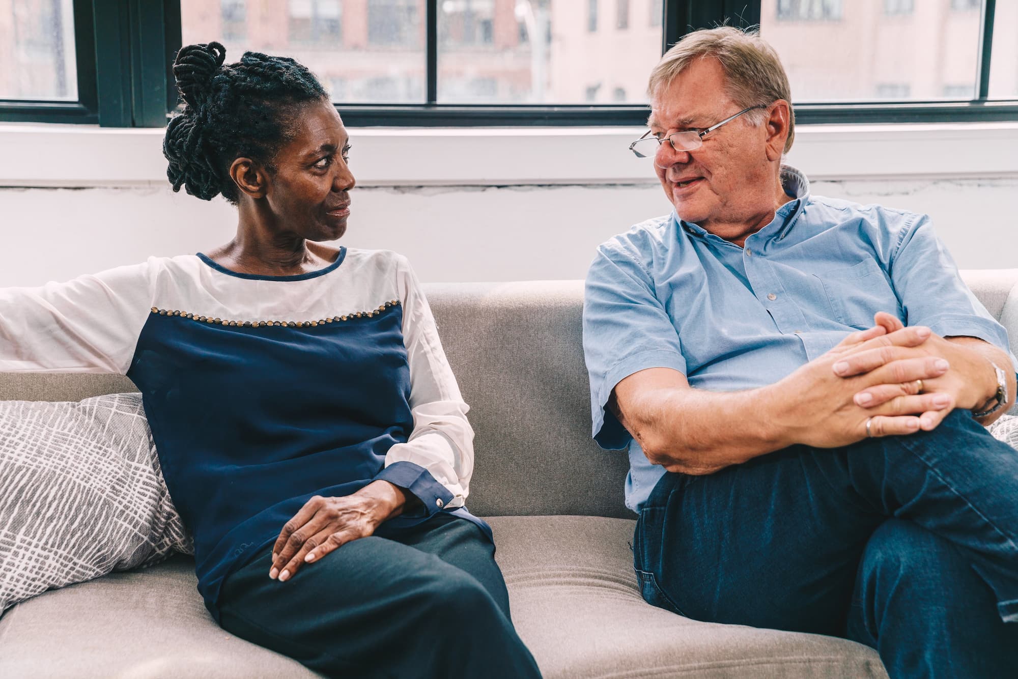 couple-sitting-on-couch-talking-through-relationship-anxiety