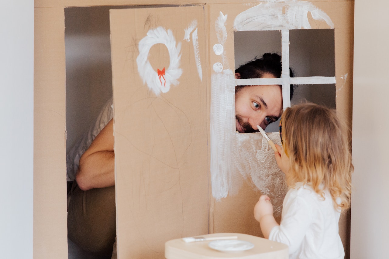 dad-playing-with-little-daughter-while-painting-cardbox-house-parenting-skills