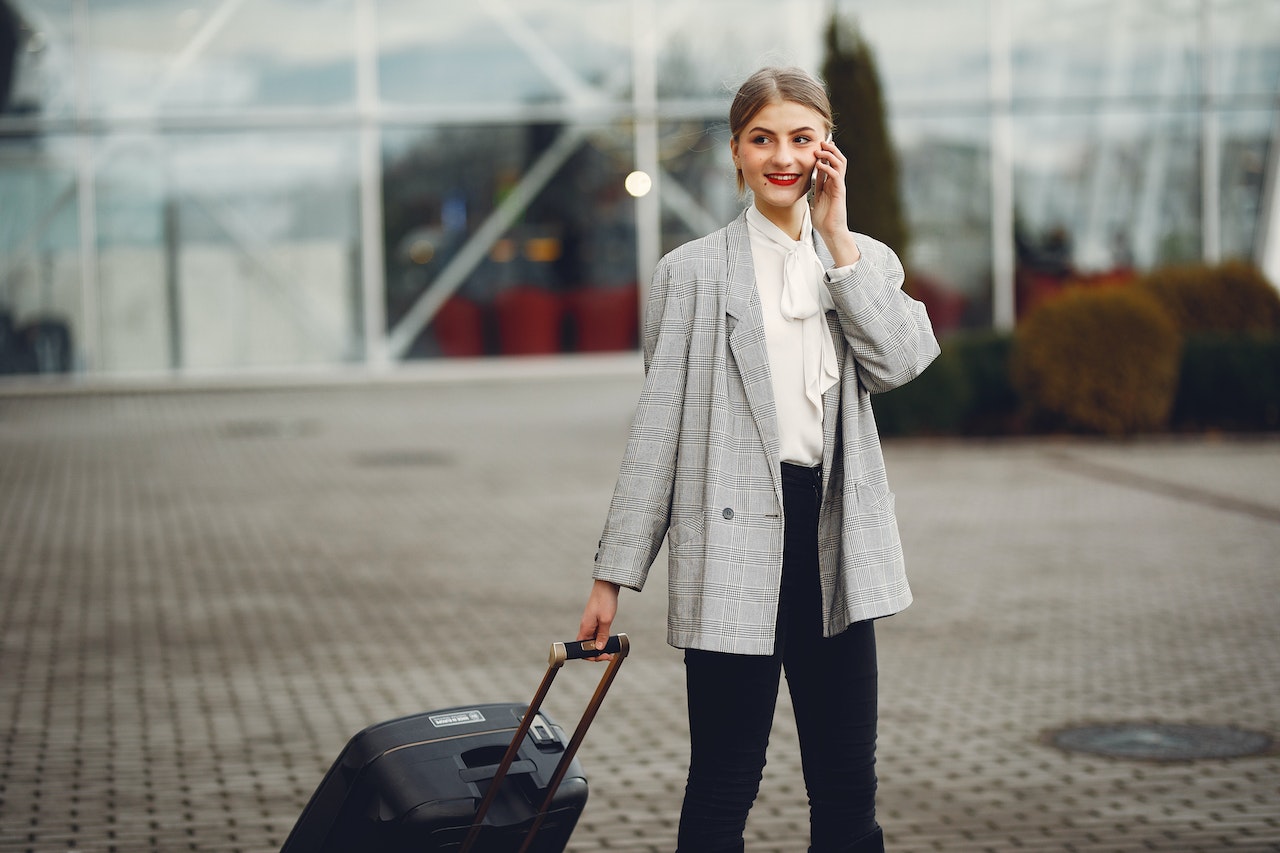 girl-taking-on-the-phone-pulling-bag-in-airport-is-personal-time-off-paid