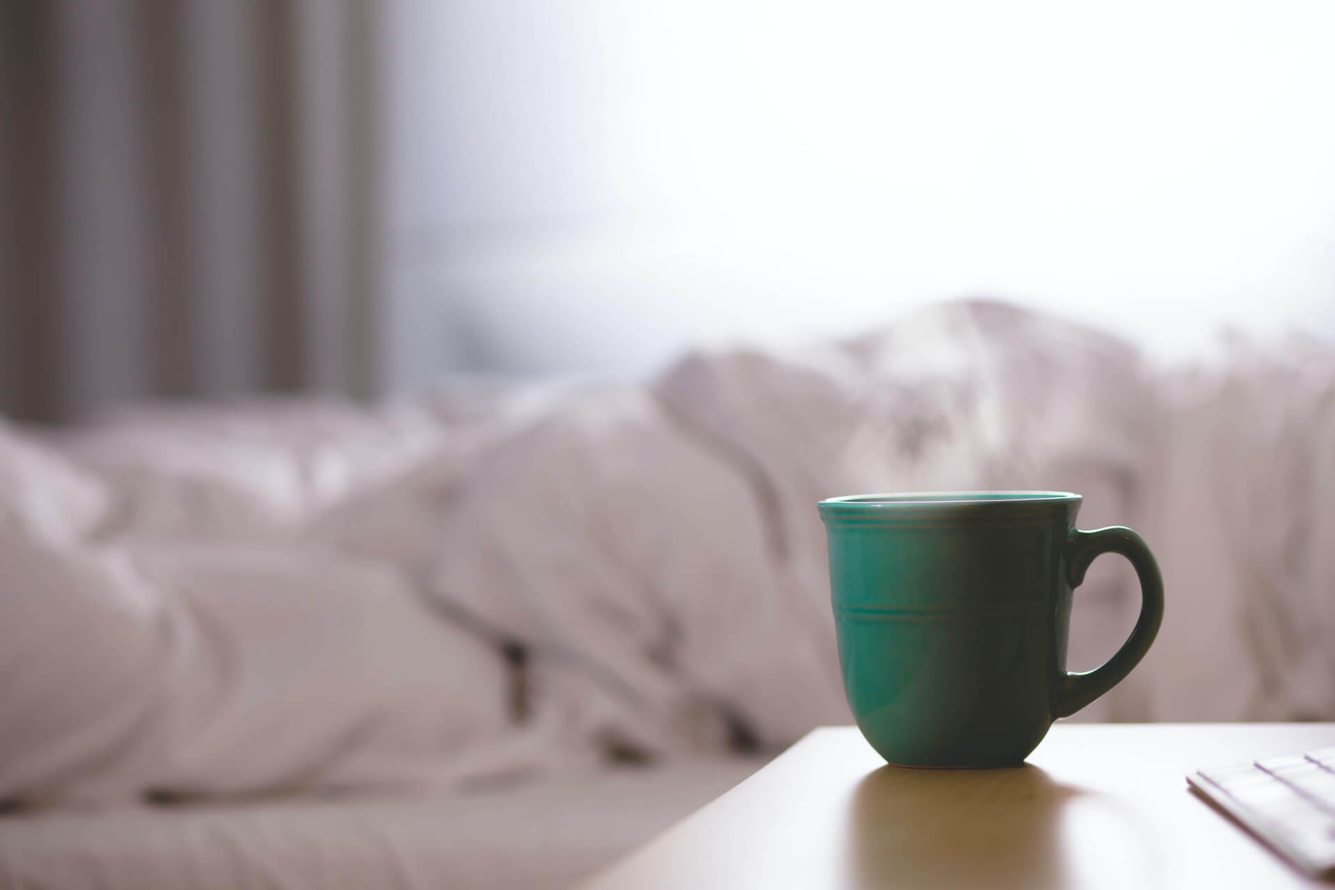 green mug next to bed after someone woke up