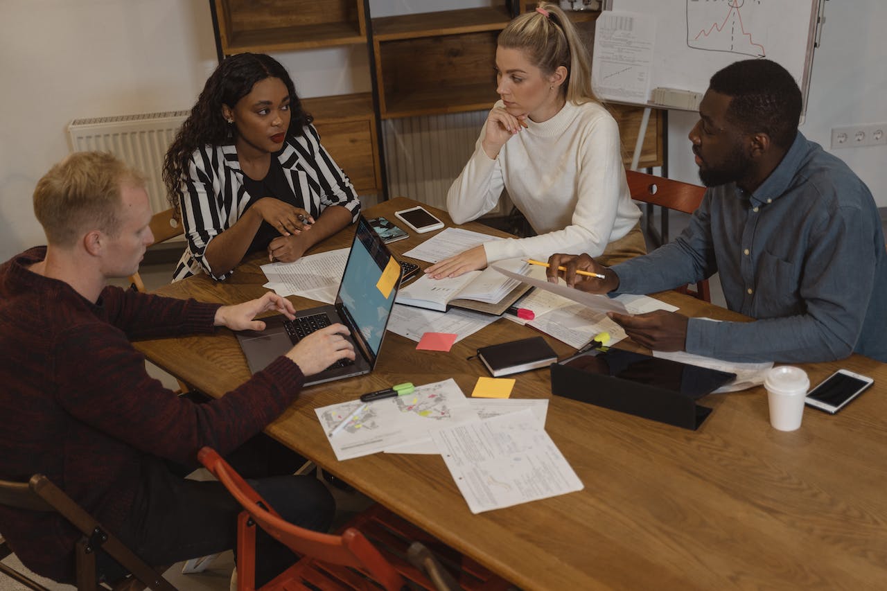 interracial-group-of-coworkers-discussing-at-the-table