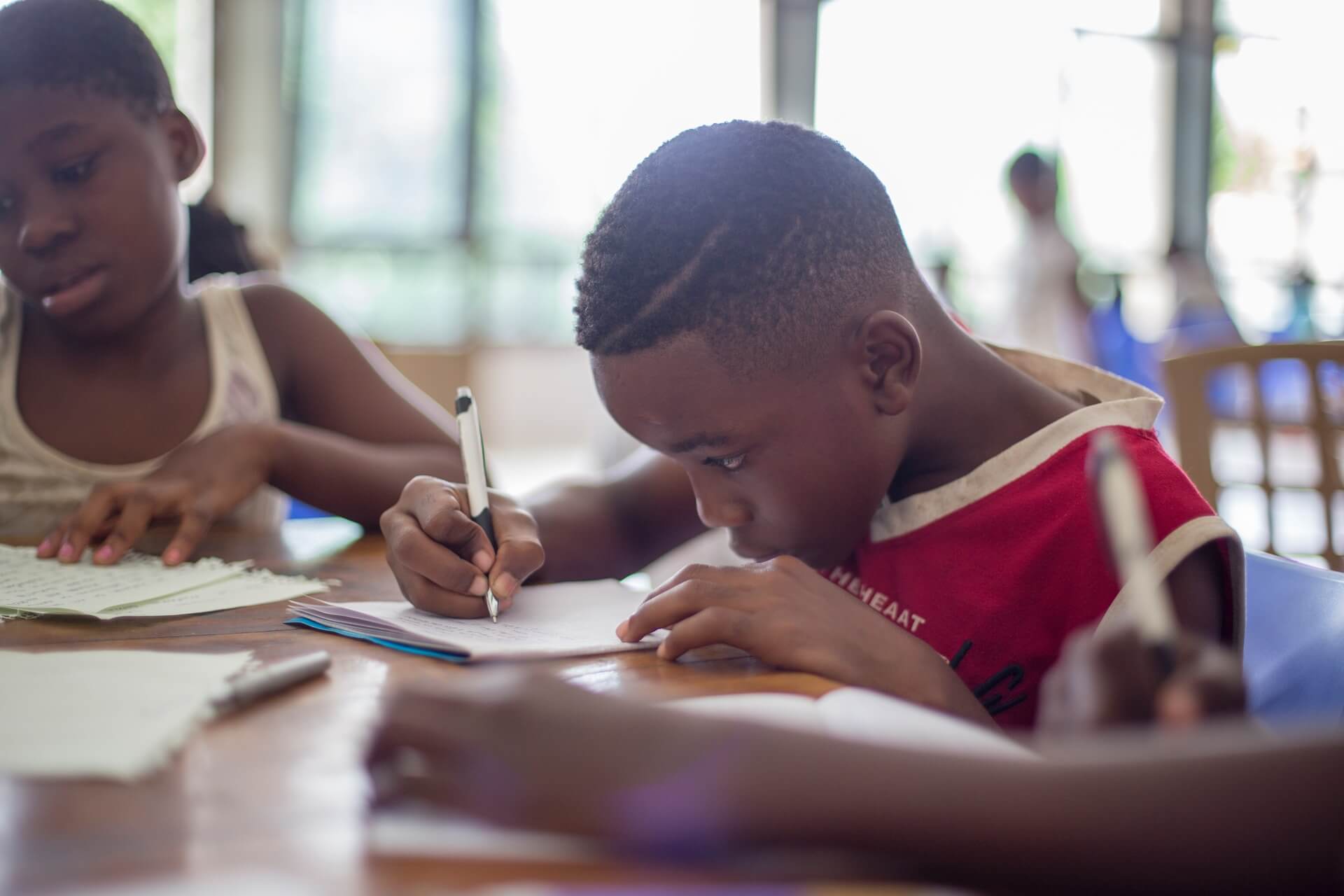 kids writing kind letters to family at table