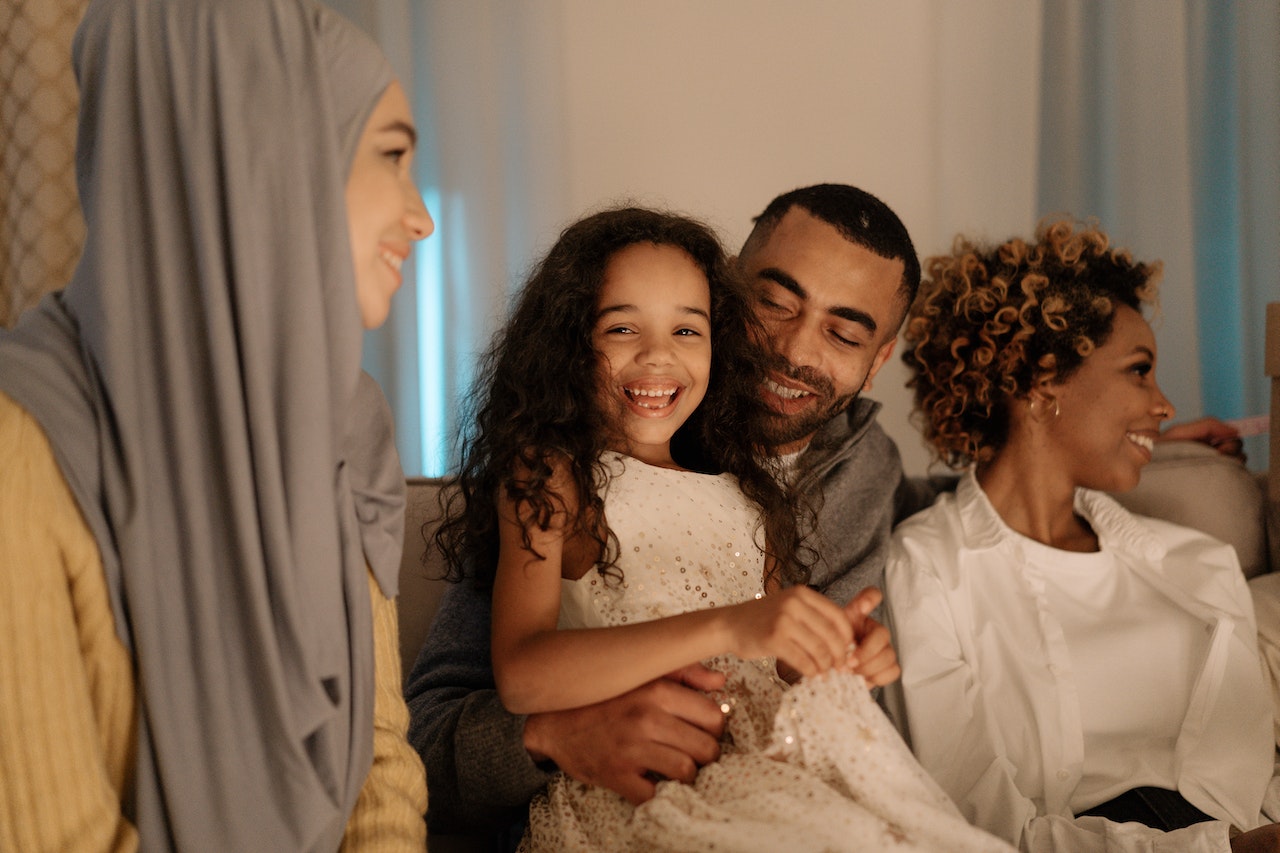little-girl-smiling-with-her-family-and-dad-holding-her-parenting-skills