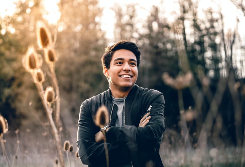 man in field smiling in blue jacket