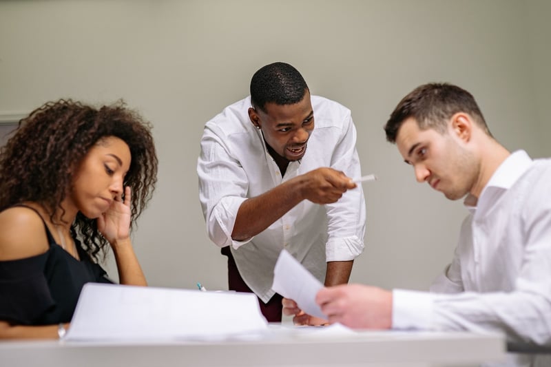 man-talking-angrily-to-coworker-at-office-with-woman-looking-stressed-how-to-quit-from-a-job-you-just-started