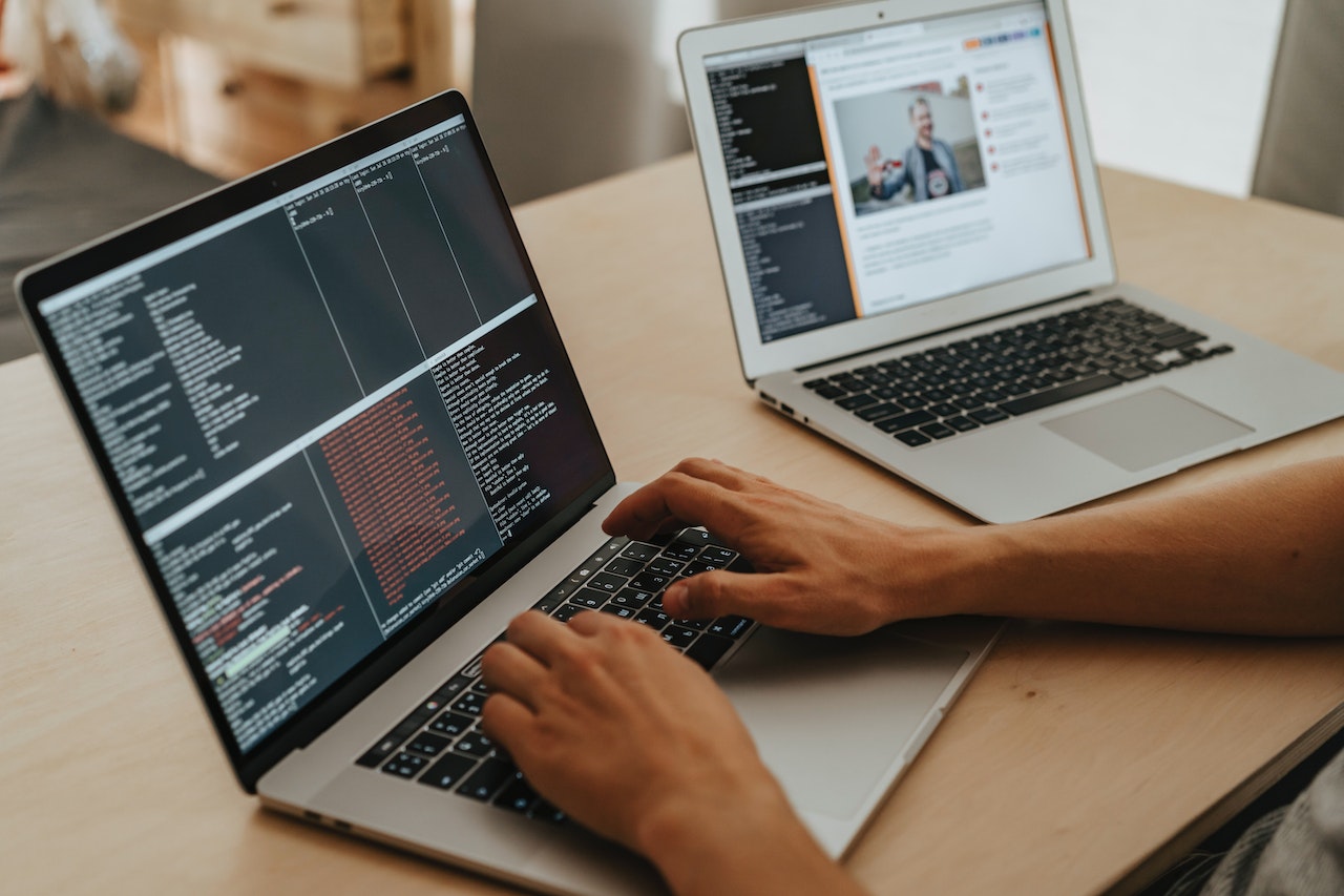 man-using-two-laptops-coding-an-ai