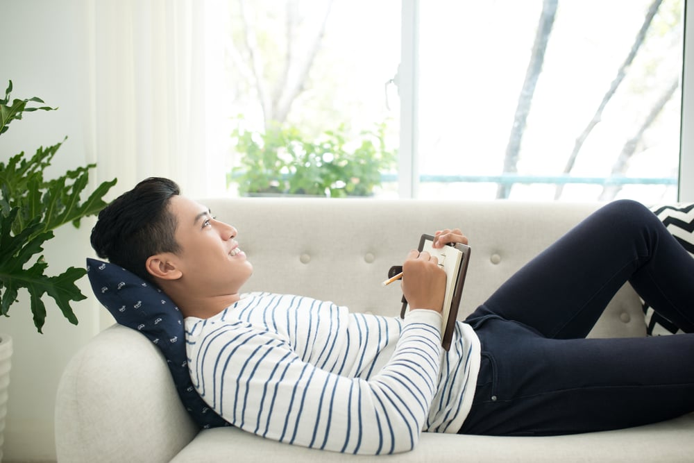 man-writing-on-his-journal-implementing-kaizen